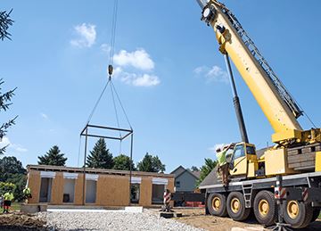 A crane places a modular Accessory Dwelling Unit