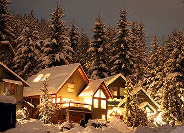 Several snow covered cabins at night