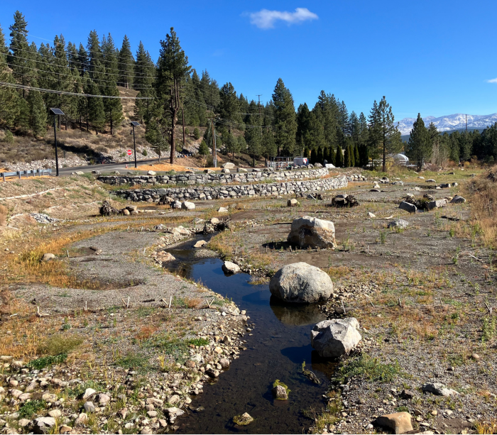 Small creek of water in dry area with rocks. 