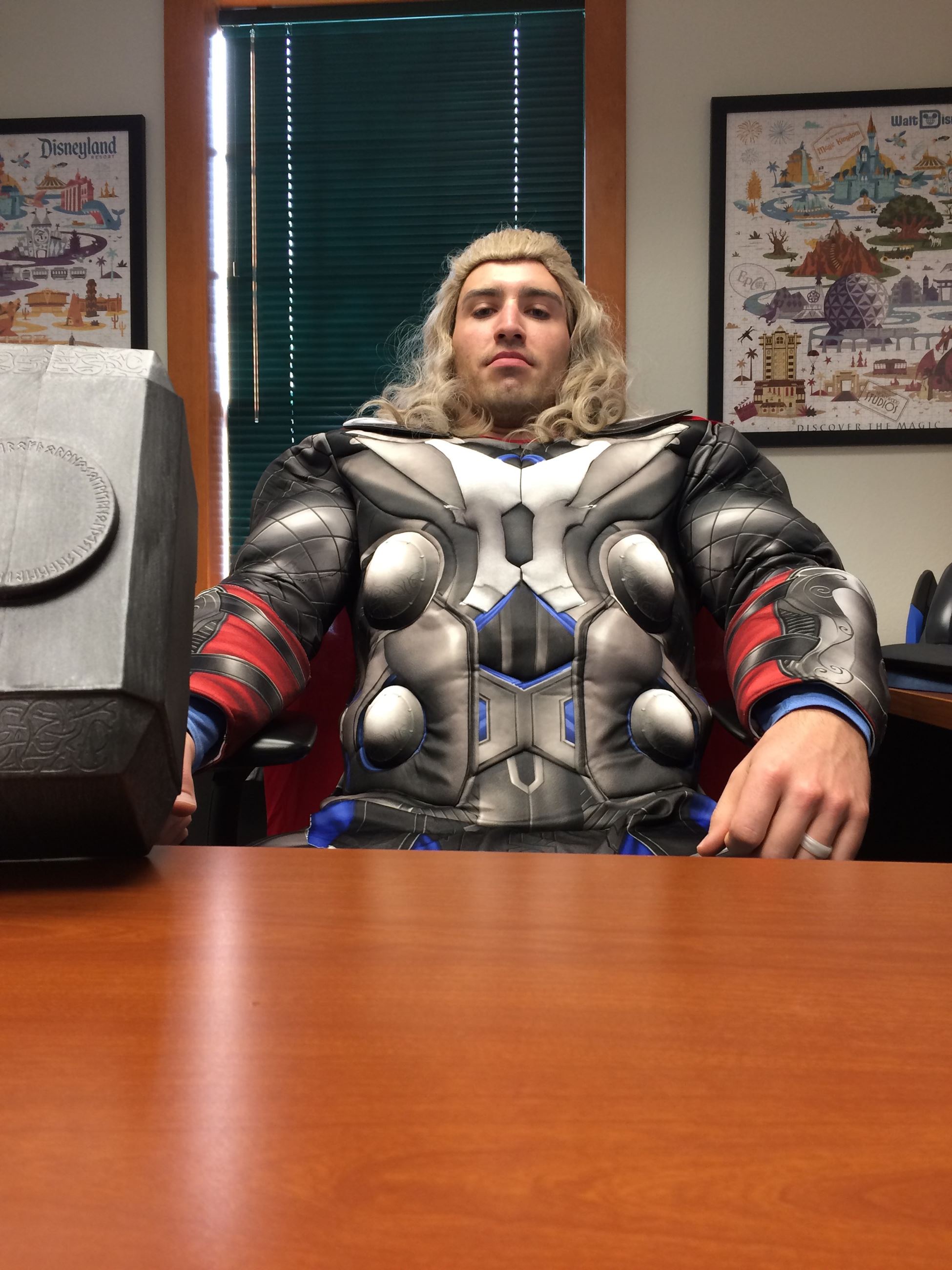 Man sitting at a desk dressed as the superhero Thor